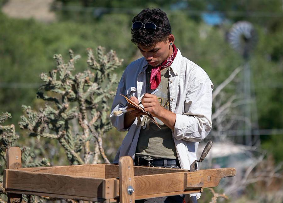 Field student Demitri DeLeon records information about artifacts recovered in the screen. (摄影:Tom Connelly)